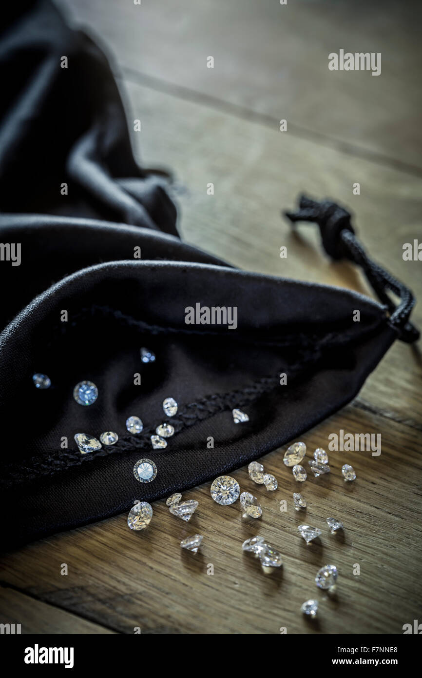 Déversant des diamants à partir d'un sac de tissu noir. Banque D'Images