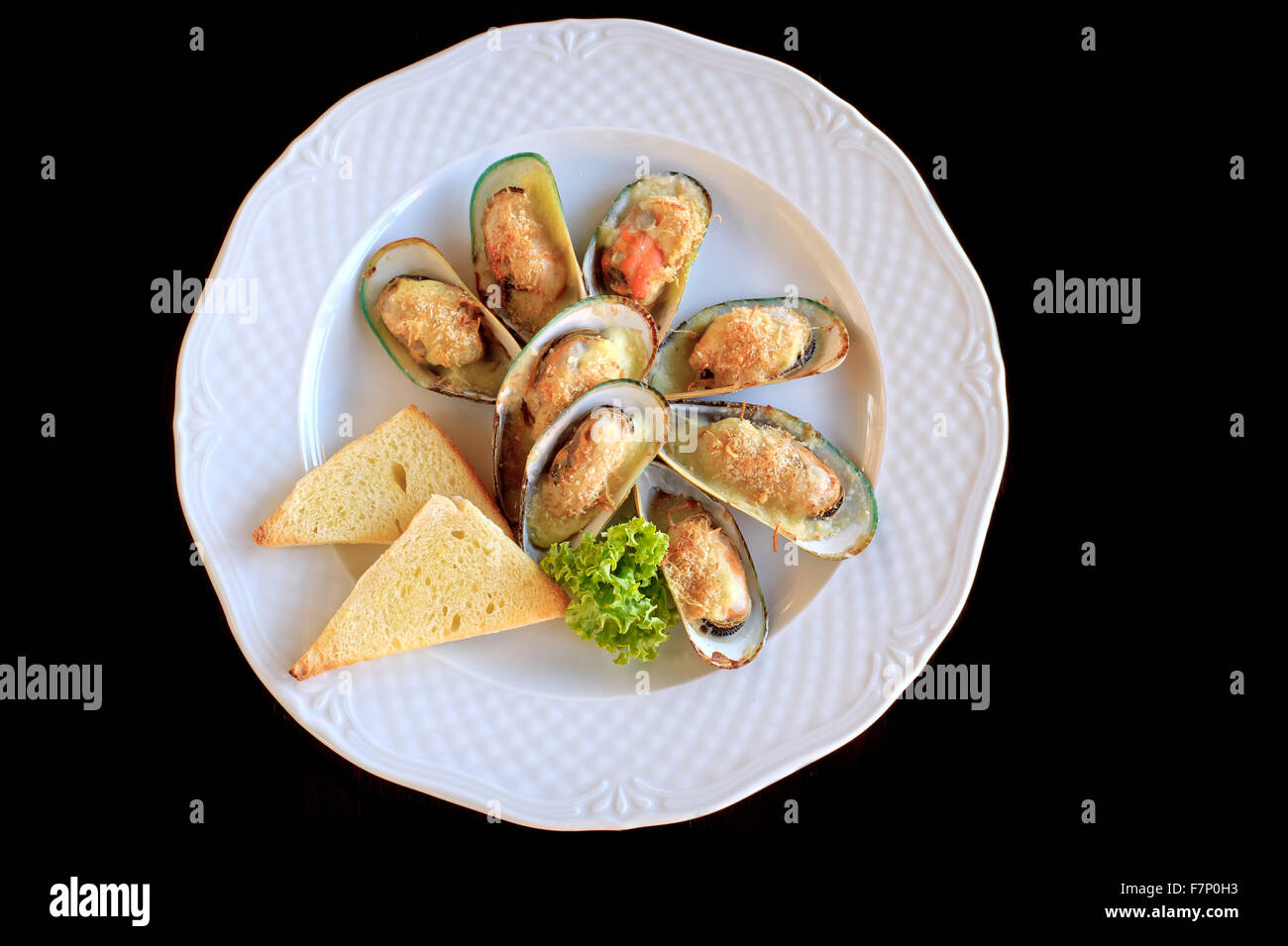 Grosses moules frites avec du fromage et du pain grillé en plaque blanche Banque D'Images