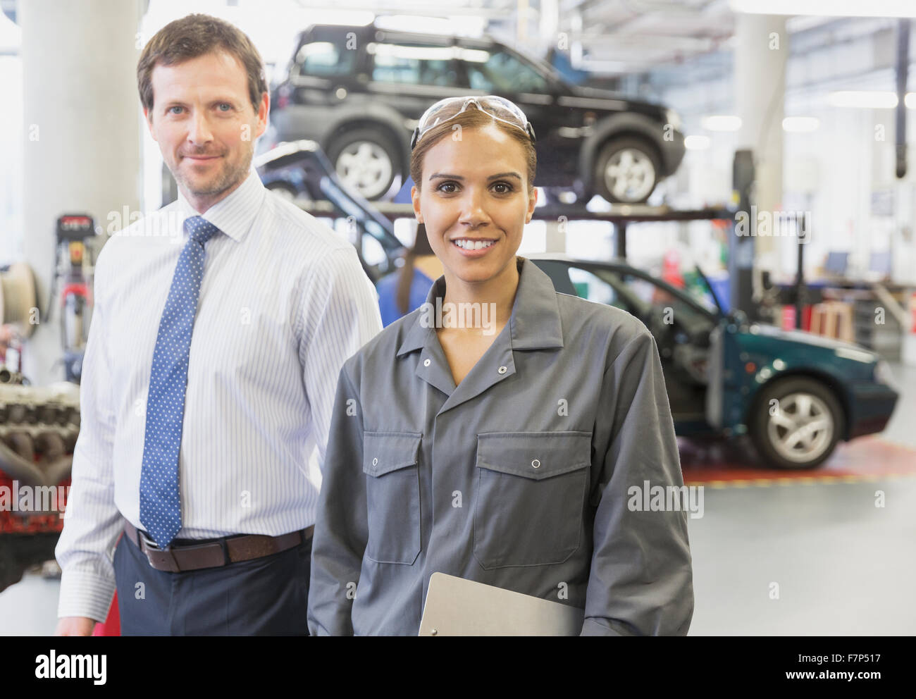 Confident businessman Portrait féminin et en mécanique auto repair shop Banque D'Images
