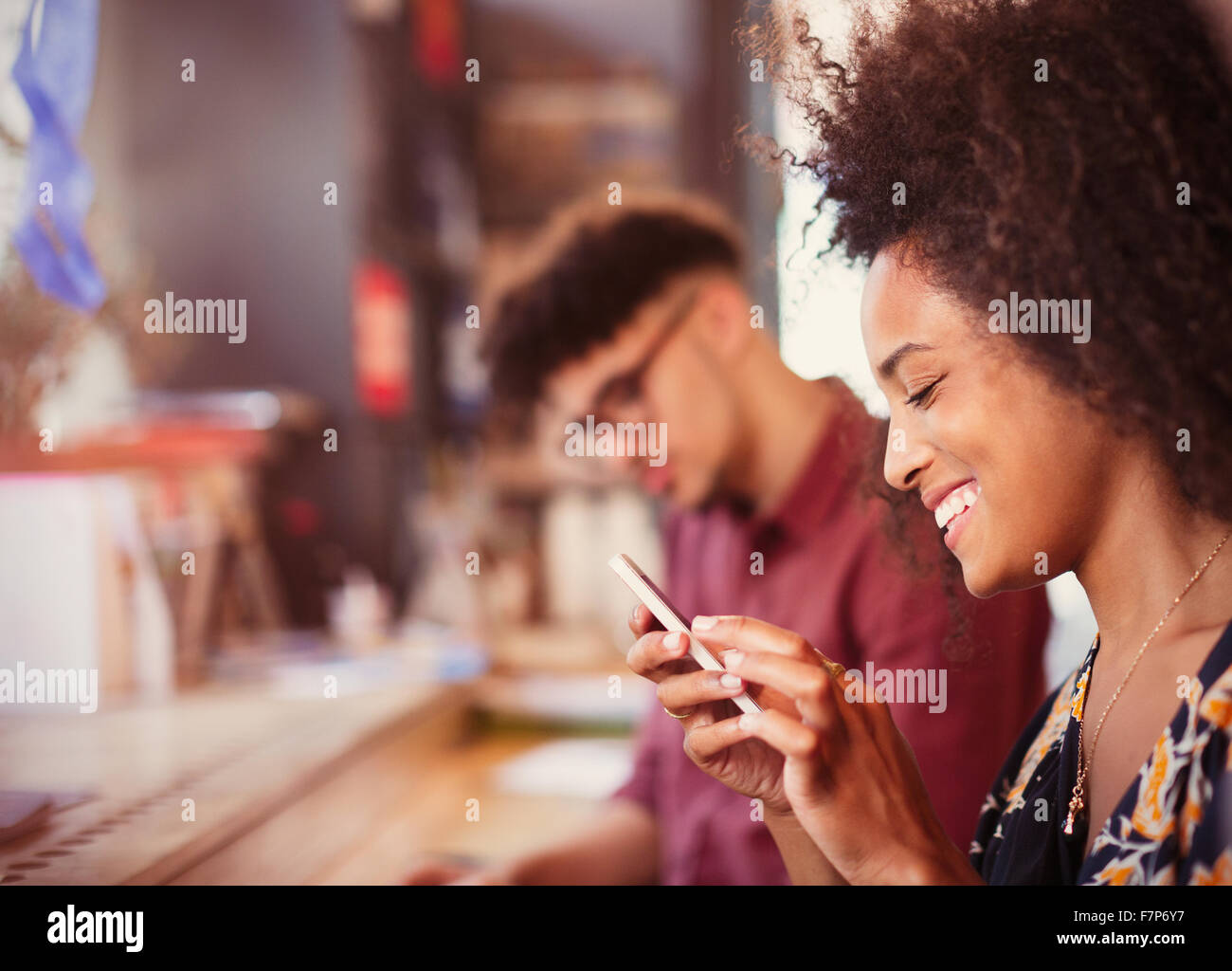 Smiling woman texting with cell phone Banque D'Images