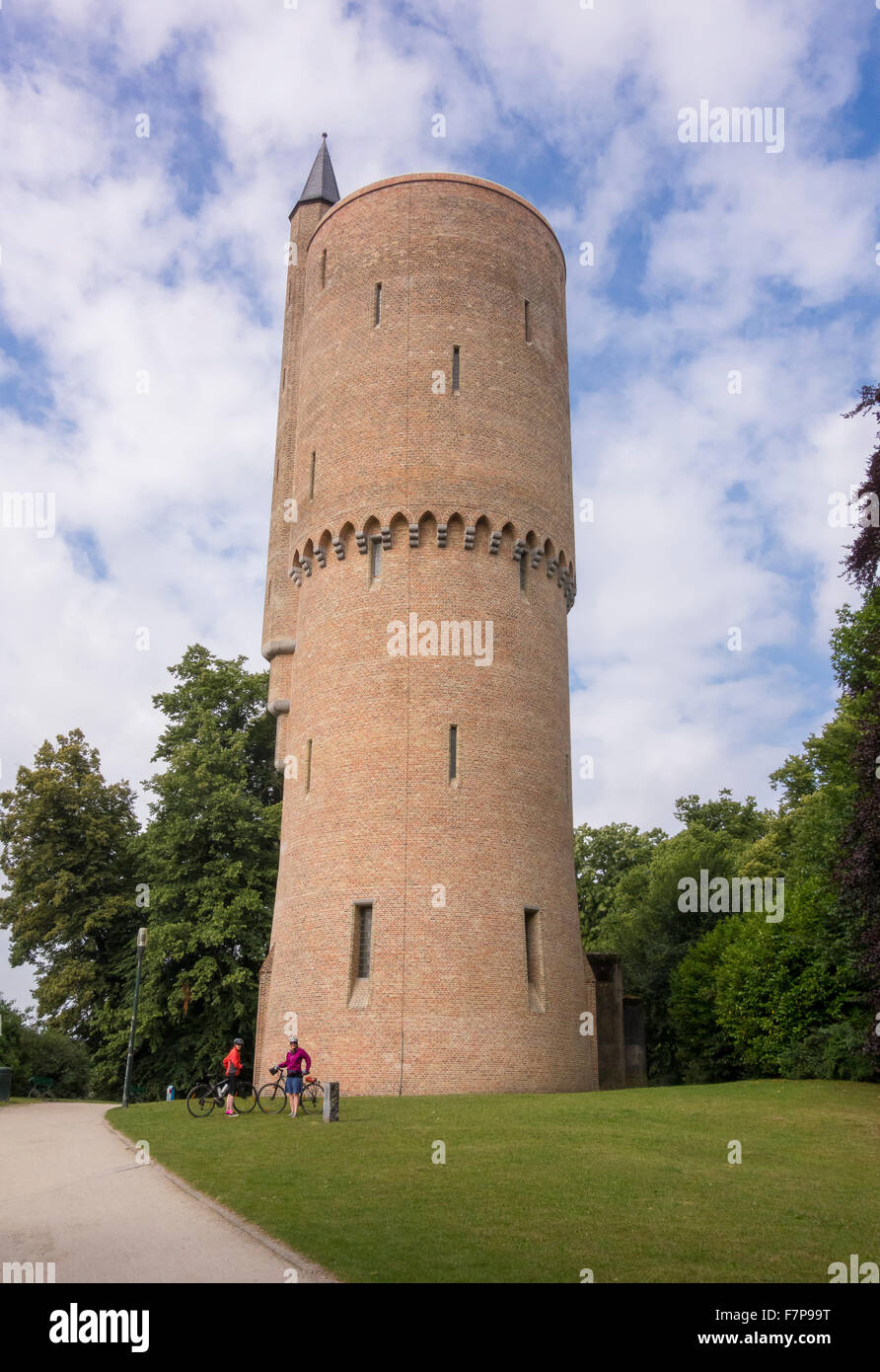 BRUGES, BELGIQUE - Minnewater tour poudrière et deux femmes sur des bicyclettes. Banque D'Images