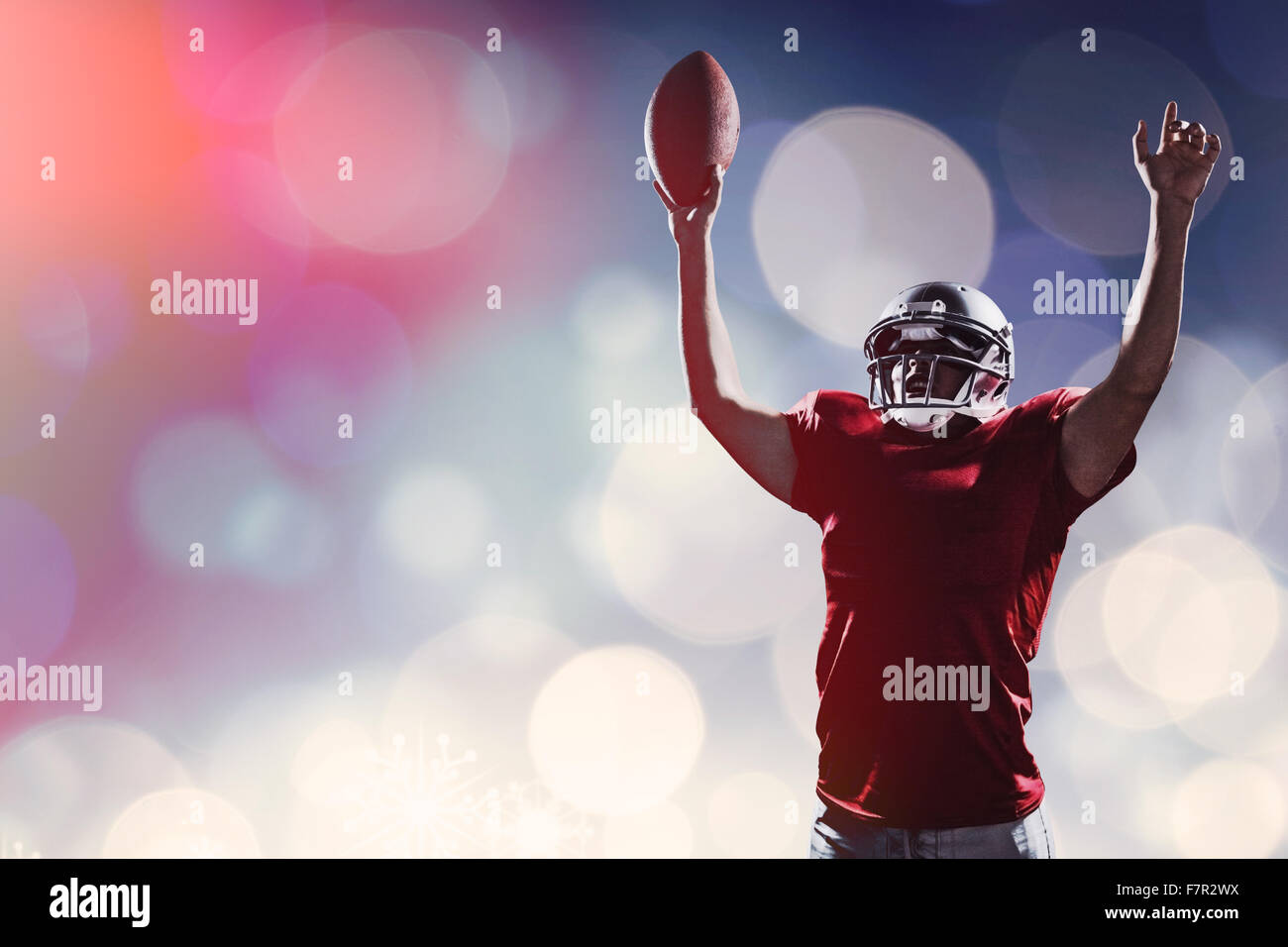 Image composite de l'american football player cheering en maintenant le ballon Banque D'Images