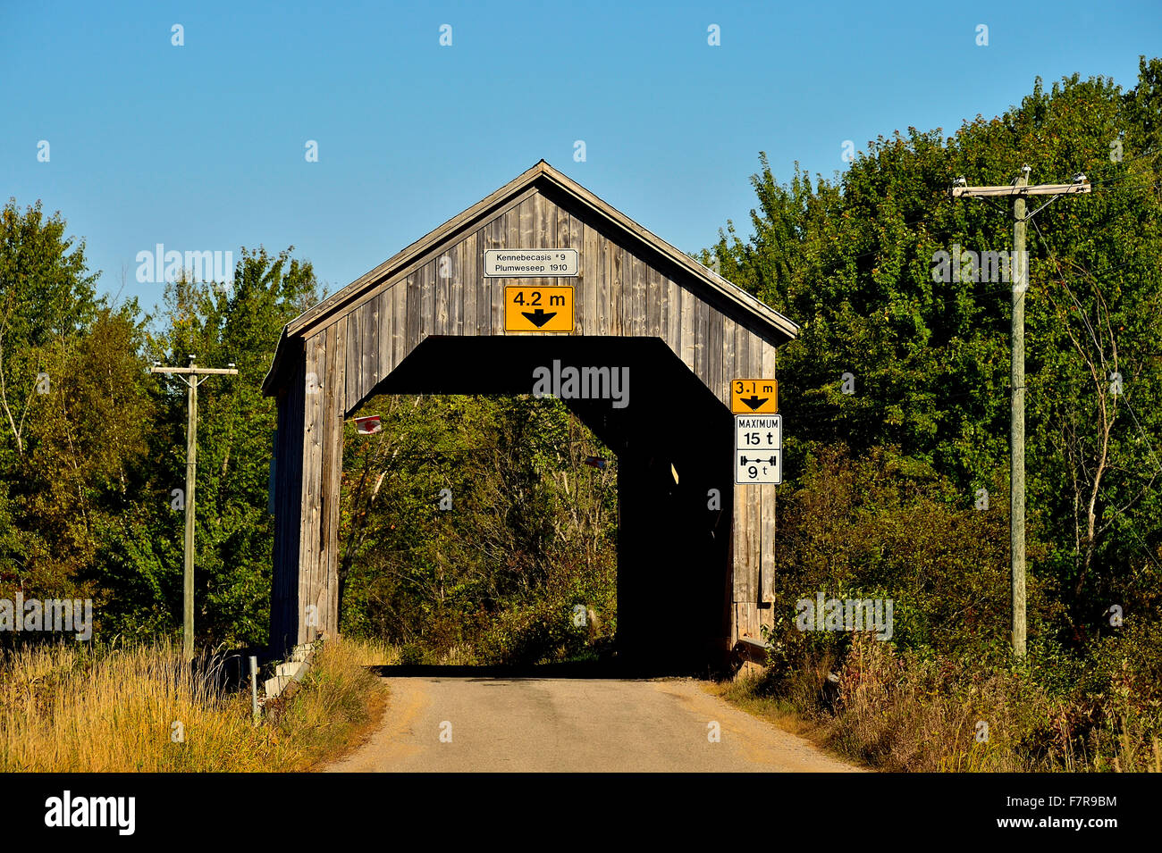 Un pont couvert en bois construit en 1910, enjambant un ruisseau sur une route à deux voies, Plumweseep dans les régions rurales du Nouveau-Brunswick Canada. Banque D'Images