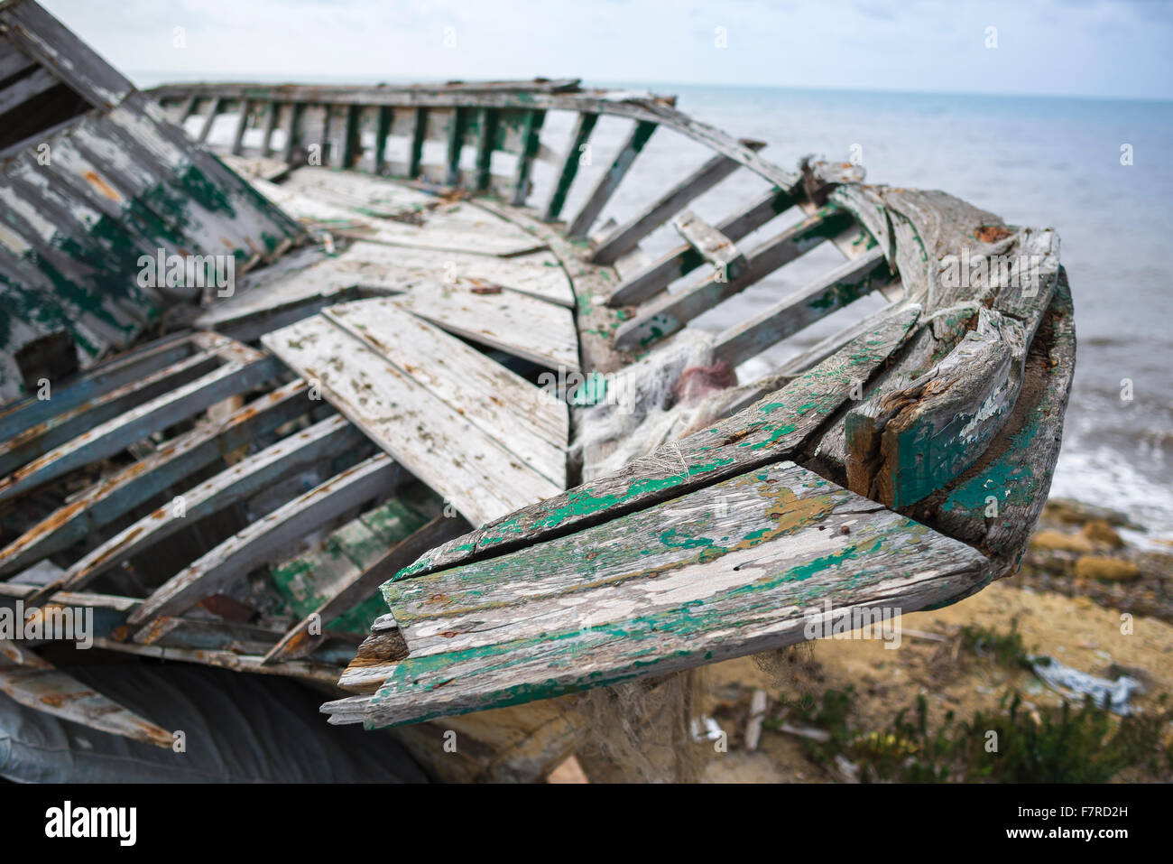 Plage bateau abandonné, vue d'un bateau de pêche abandonnés à la décomposition de gauche à côté de la digue à Marsala, en Sicile. Banque D'Images