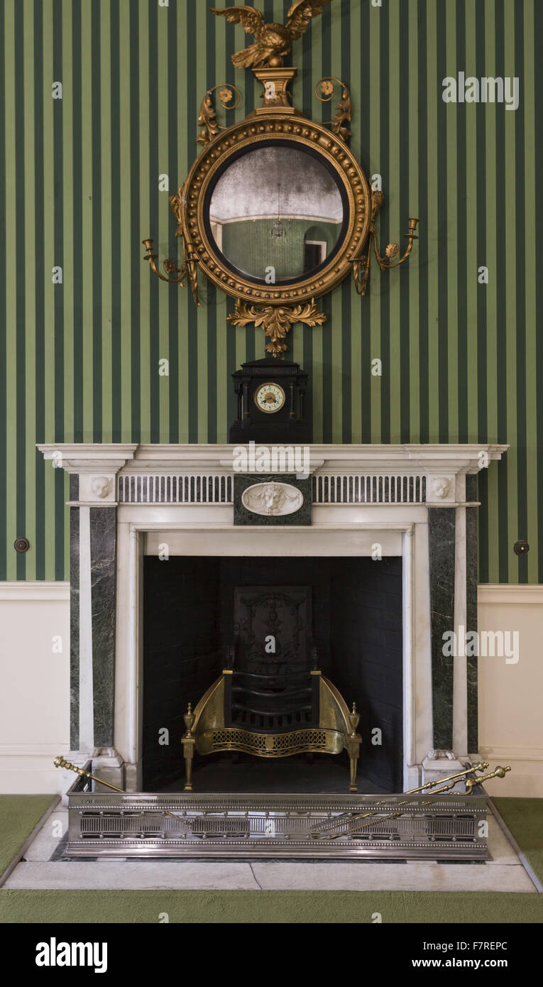 Miroir en bois doré de style Régence accroché au-dessus d'une cheminée, dans une chambre à Polesden Lacey, Surrey. Banque D'Images