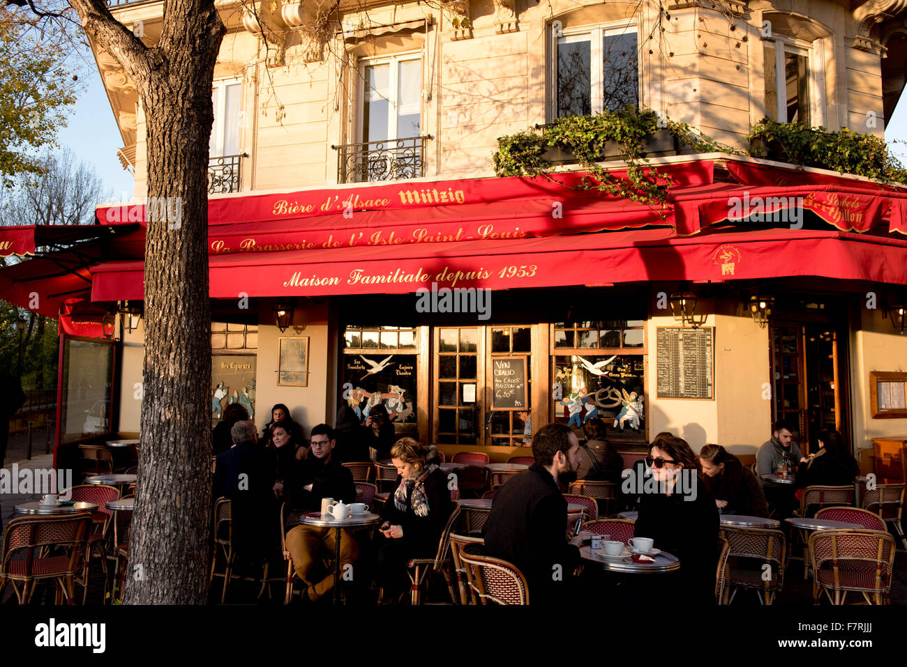 Les gens assis à des tables de la chaussée à un café animé sur l'Ile Saint Louis, Paris, France Banque D'Images