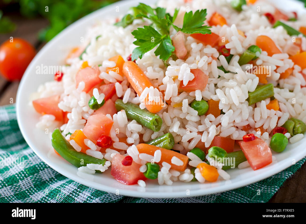 Riz aux légumes sains appétissants en plaque blanche sur un fond de bois. Banque D'Images