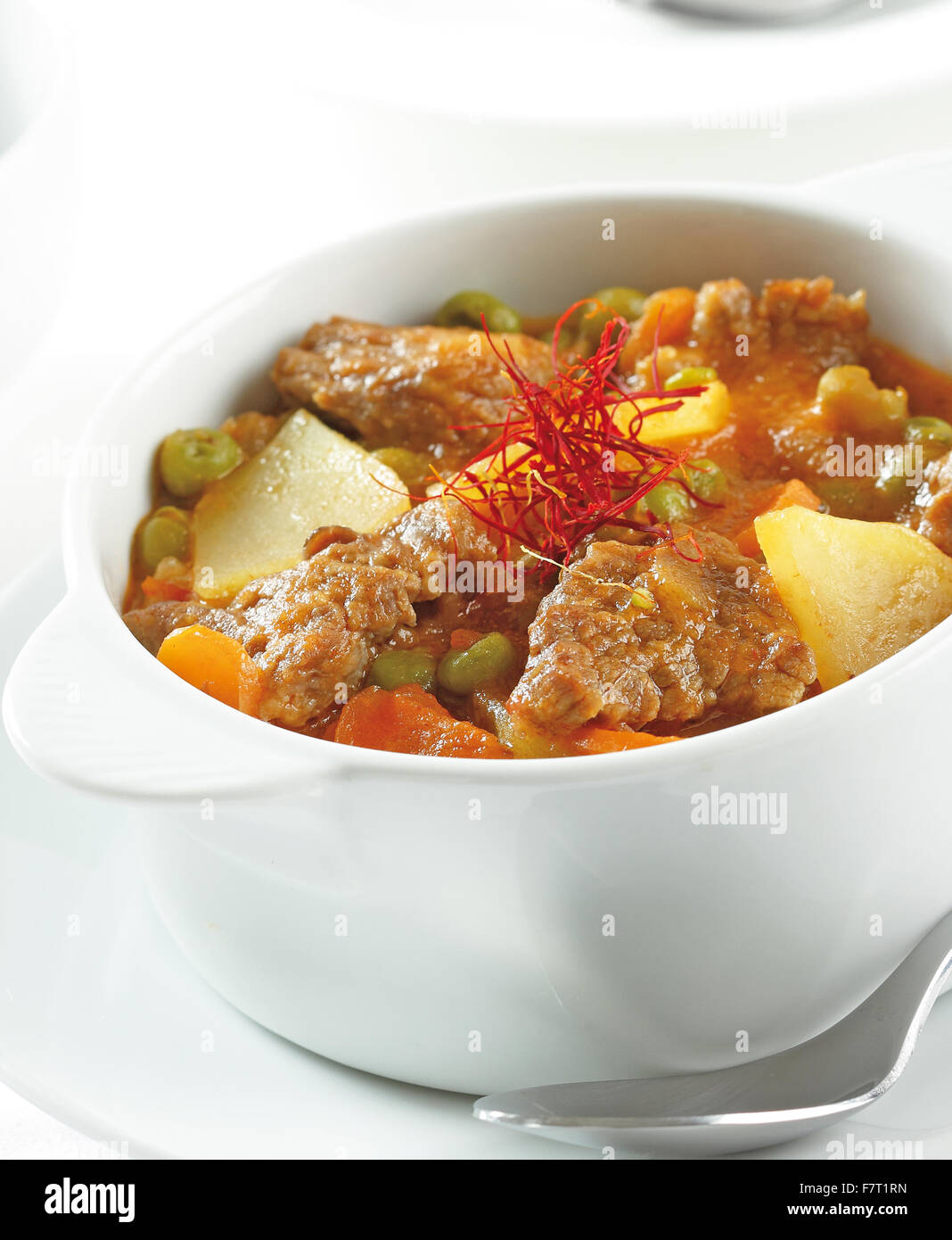 Un ragoût de boeuf avec pommes de terre, petits pois, carottes et le safran. Banque D'Images