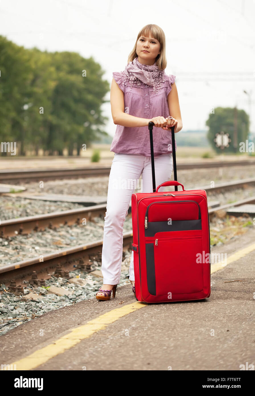 Femme avec une assurance train en attente sur railroad Banque D'Images