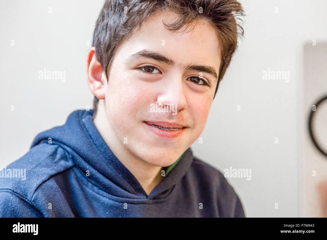 Young boy heureux et souriant à bretelles sur les dents Banque D'Images