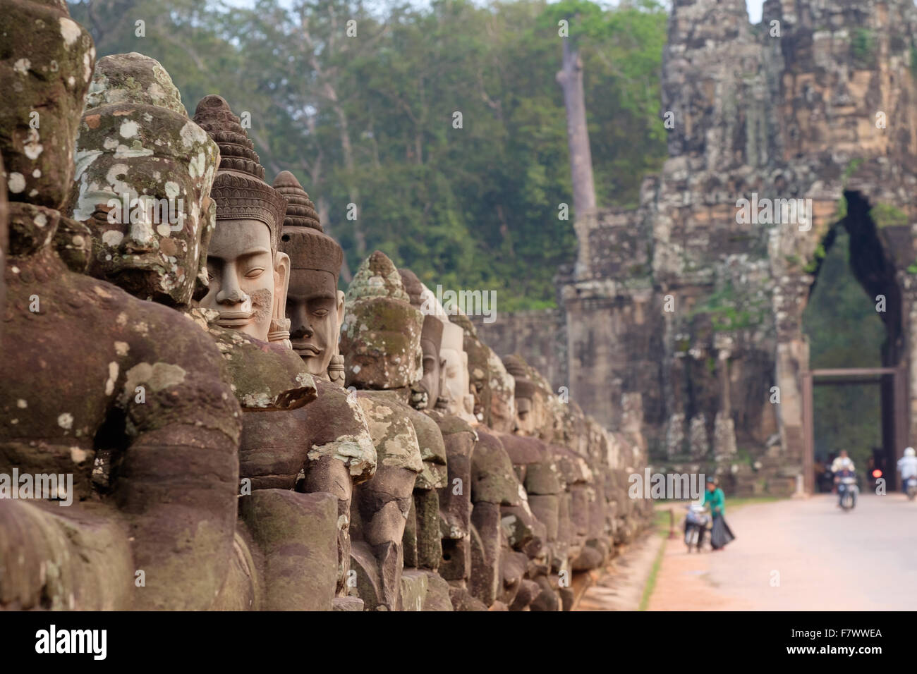 Visages sculptés en pierre sur le pont à la porte sud d'Angkor Thom temples Banque D'Images