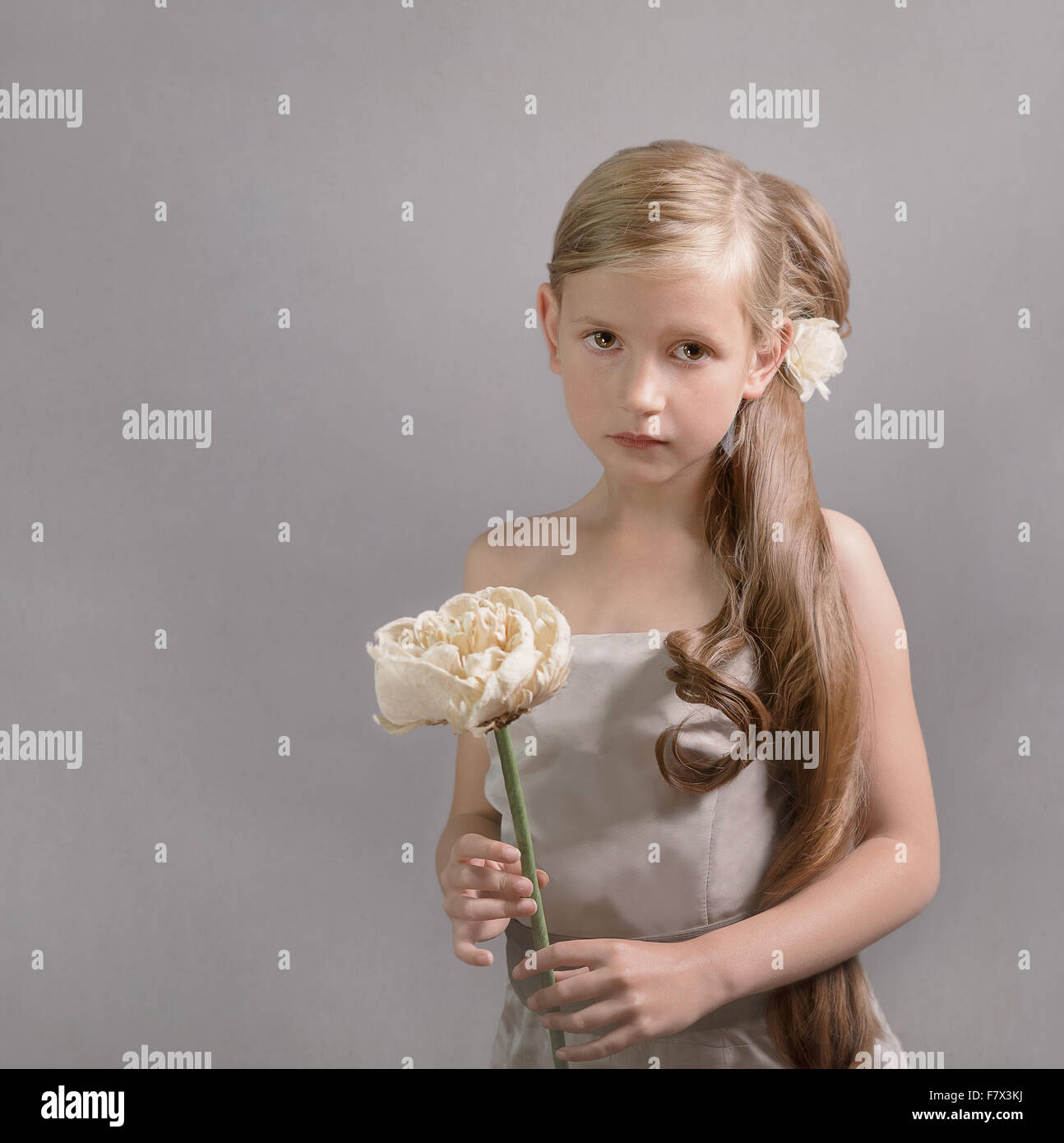 Portrait d'une fille avec queue tient une fleur Banque D'Images
