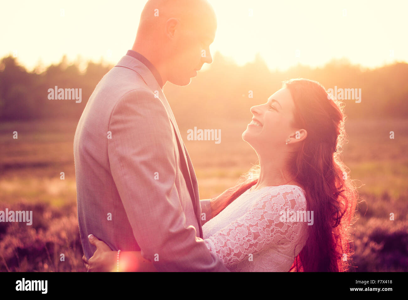 Smiling couple embracing outdoors at sunset Banque D'Images