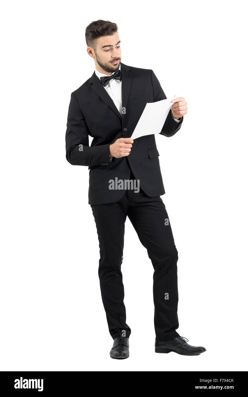 Élégant jeune groom holding et la lecture de documents papier. La pleine longueur du corps portrait studio isolated over white background Banque D'Images