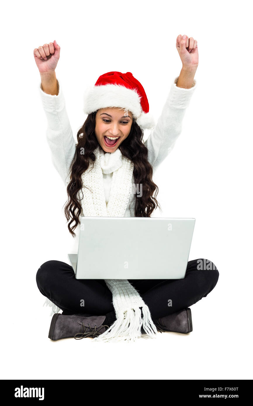 Femme assise sur le sol se réjouissant looking at laptop Banque D'Images