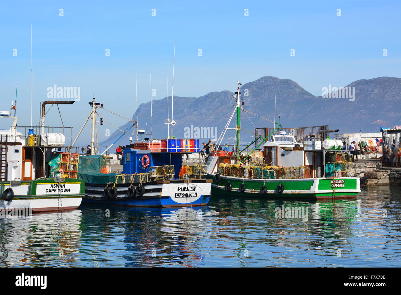 Bateaux de pêche au port de Kalk Bay Afrique du Sud avec les montagnes autour de False Bay à l'arrière-plan. Banque D'Images