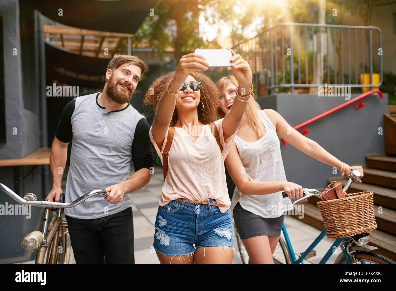 Jeune femme africaine en prenant un autoportrait avec ses amis. Femme africaine en tenant avec selfies téléphone mobile. Jeunes amis avec b Banque D'Images