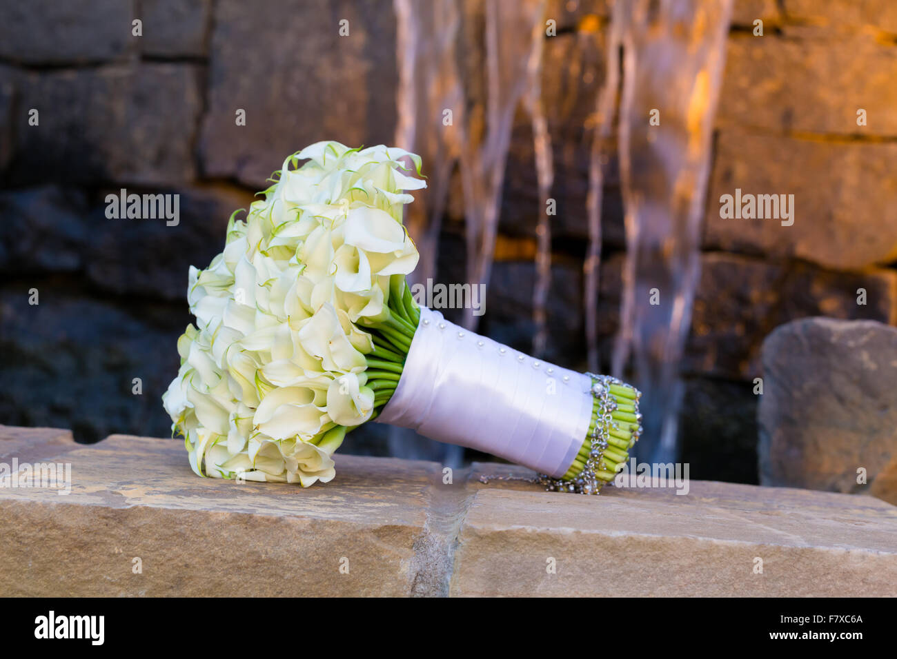 Fleurs Mariage organisé en un bouquet pour la mariée le jour de son mariage sur un mur de ciment avec de l'eau dans l'arrière-plan. Banque D'Images