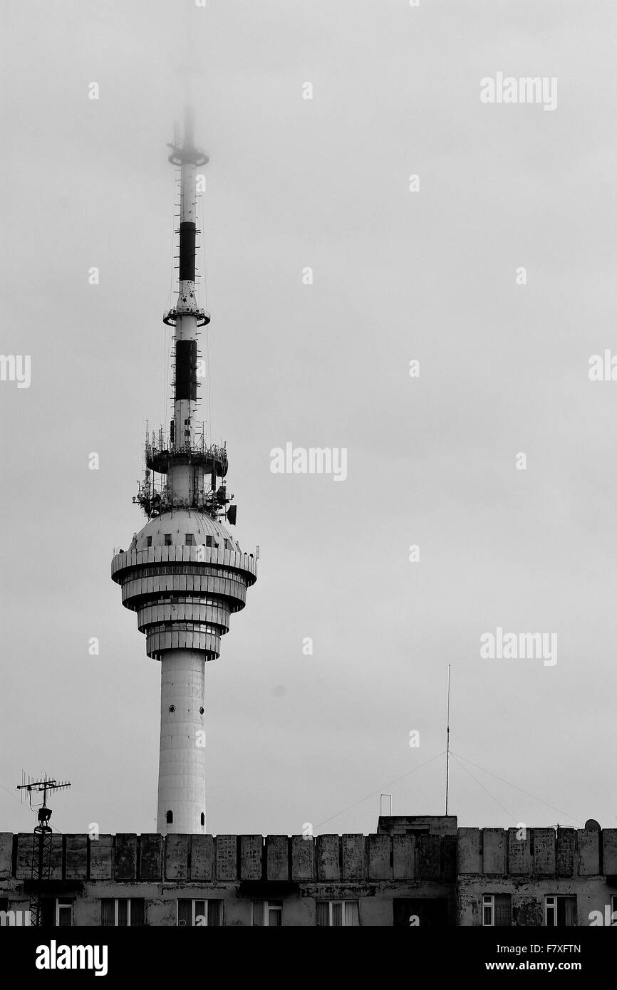 La tour de télécommunications de Bakou disparaissant dans les nuages dans la capitale de l'Azerbaïdjan, en noir et blanc Banque D'Images