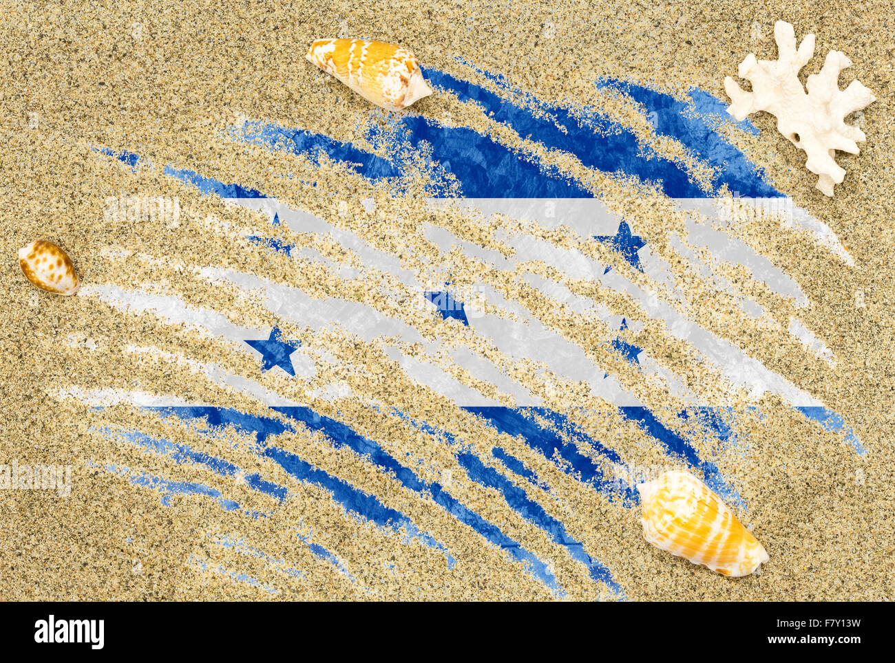 Drapeau du pays national du Honduras sous un fond de plage de sable, de coquillages et de corail Banque D'Images
