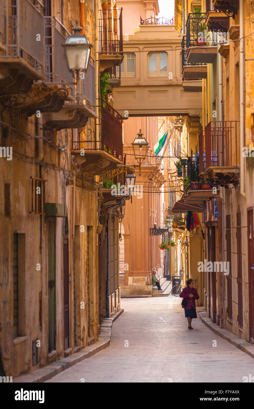 Marsala Sicile, vue en été d'une femme âgée marchant seule dans la via Mario Rapisardi dans le centre historique de Marsala, Sicile. Banque D'Images