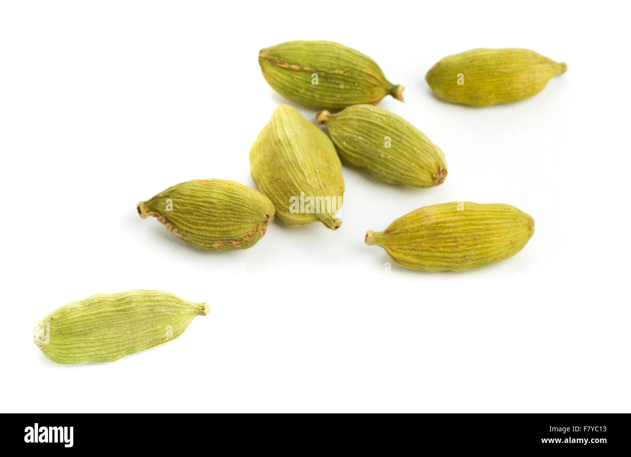 Les gousses de cardamome close up avec une faible profondeur de champ sur fond blanc Banque D'Images