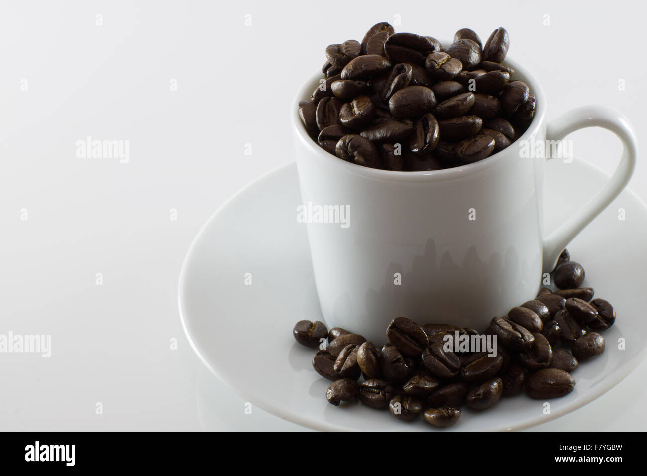 Tasse blanche avec les grains de café Banque D'Images