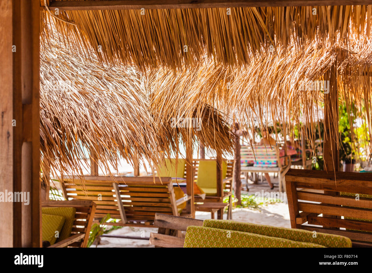 Un restaurant thaïlandais sur une plage tropicale avec des parasols de paille Banque D'Images