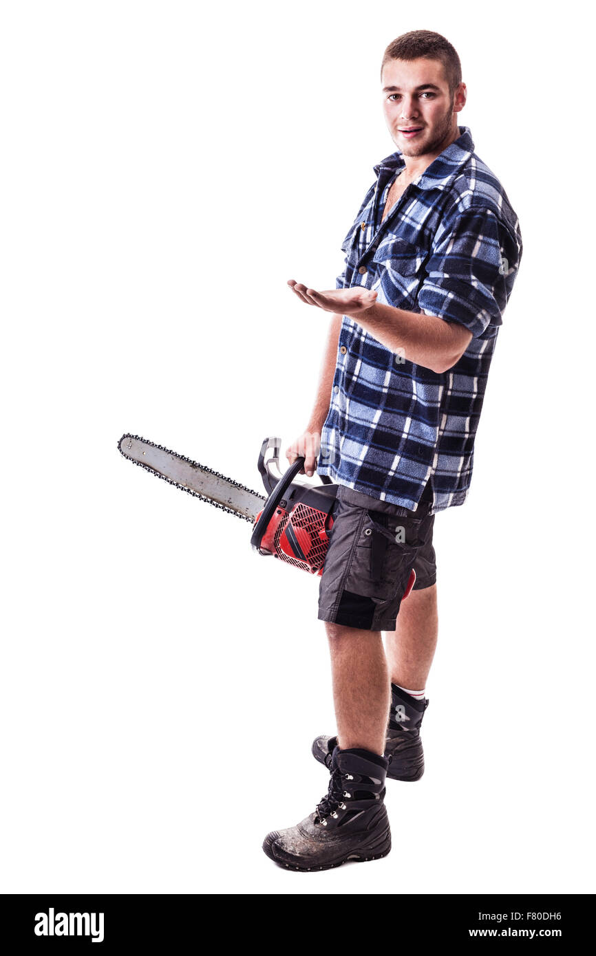 Un jeune bûcheron portant une chemise à carreaux à la main une scie à chaîne et montrant quelque chose d'isolé sur fond blanc Banque D'Images