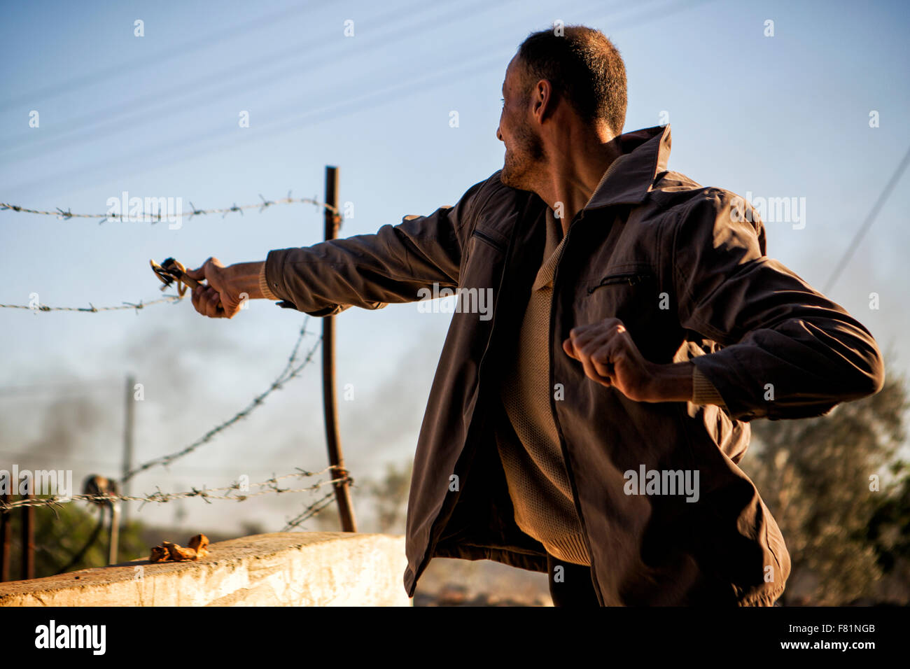 Près de Ramallah, Cisjordanie, Proche-Orient. 4 Décembre, 2015. Un Palestinien de forêt sa fronde à l'égard des soldats israéliens lors d'affrontements ce vendredi près de Ramallah, Cisjordanie Crédit : Rey T. Byhre/Alamy Live News Banque D'Images