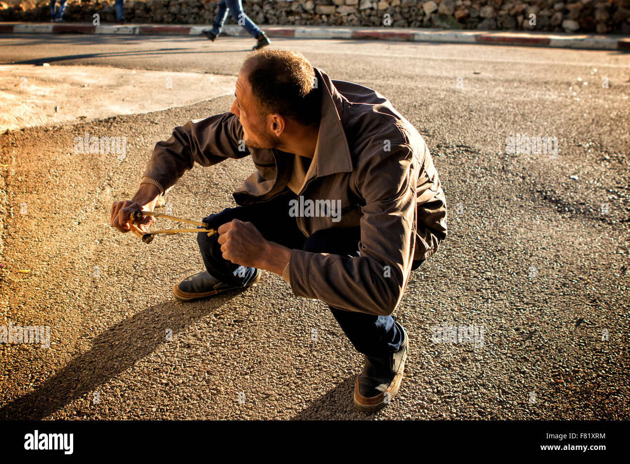 Près de Ramallah, Cisjordanie, Proche-Orient. 4 Décembre, 2015. Un Palestinien de forêt sa fronde à l'égard des soldats israéliens lors d'affrontements ce vendredi près de Ramallah, Cisjordanie Crédit : Rey T. Byhre/Alamy Live News Banque D'Images