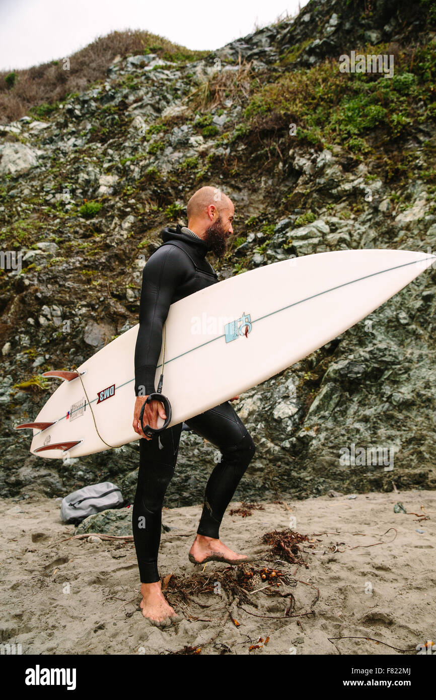 Un internaute vient dans de l'eau sur une plage de Big Sur, en Californie. Banque D'Images
