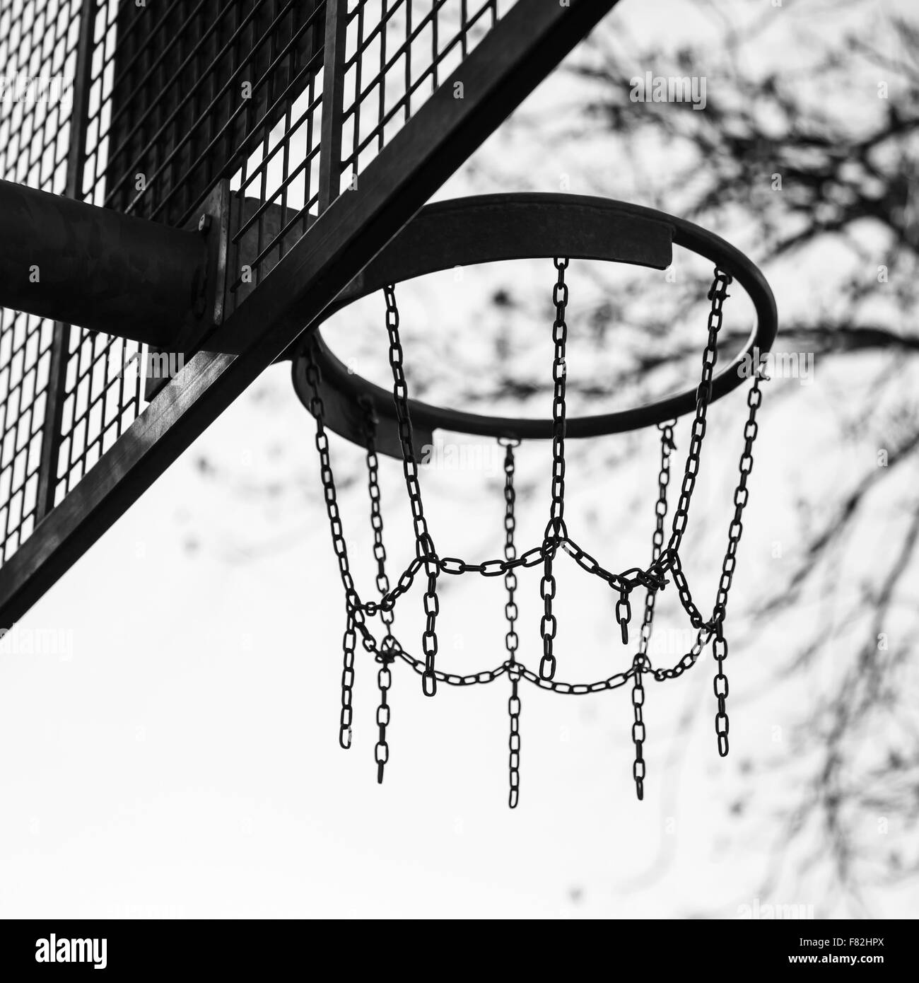 Panier fait de chaînes pour le jeu de basket-ball sur l'aire de jeux dans un parc de la ville, photo en noir et blanc Banque D'Images