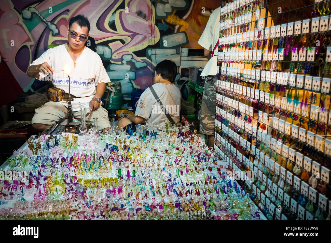 Un homme faire verre souvenirs au marché de nuit à pied le long de Wualai Road à Chiang Mai, Thaïlande. Banque D'Images