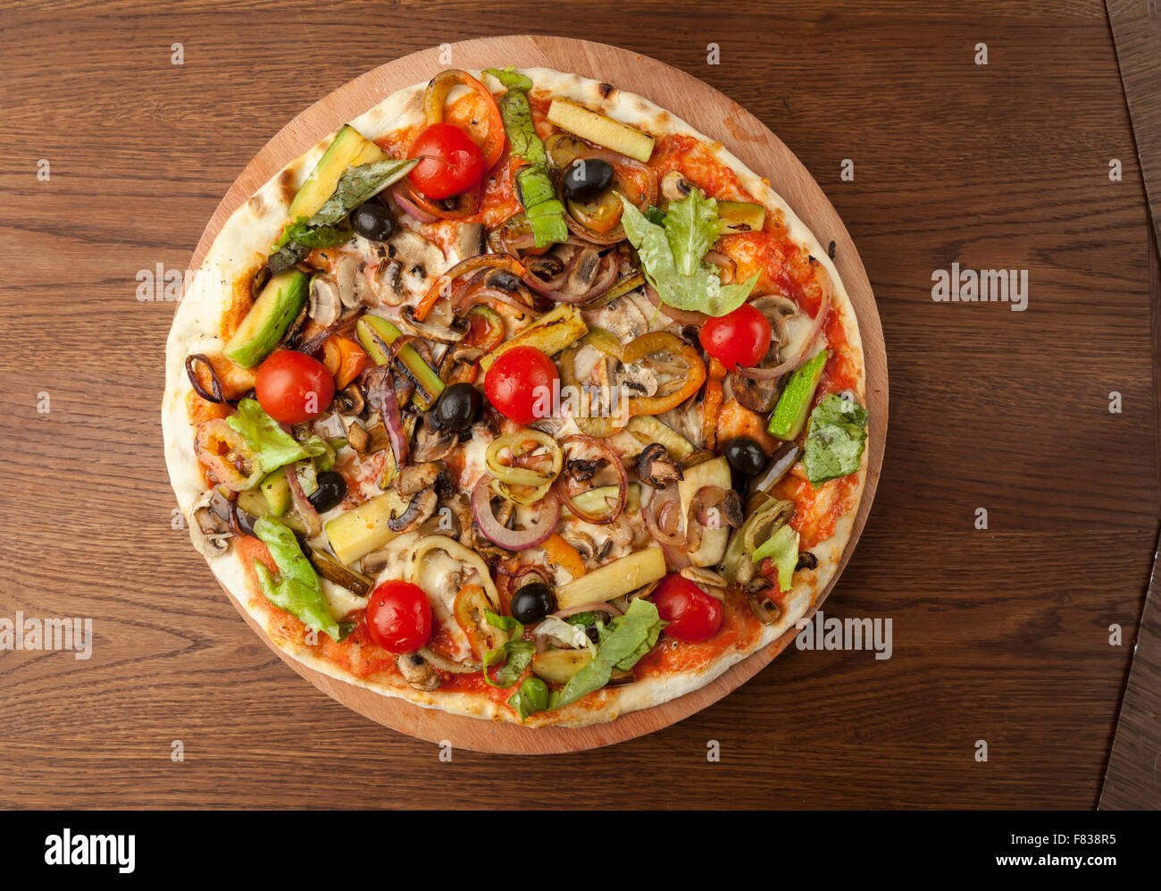 Pizza végétarienne avec des légumes sur plaque de bois Banque D'Images
