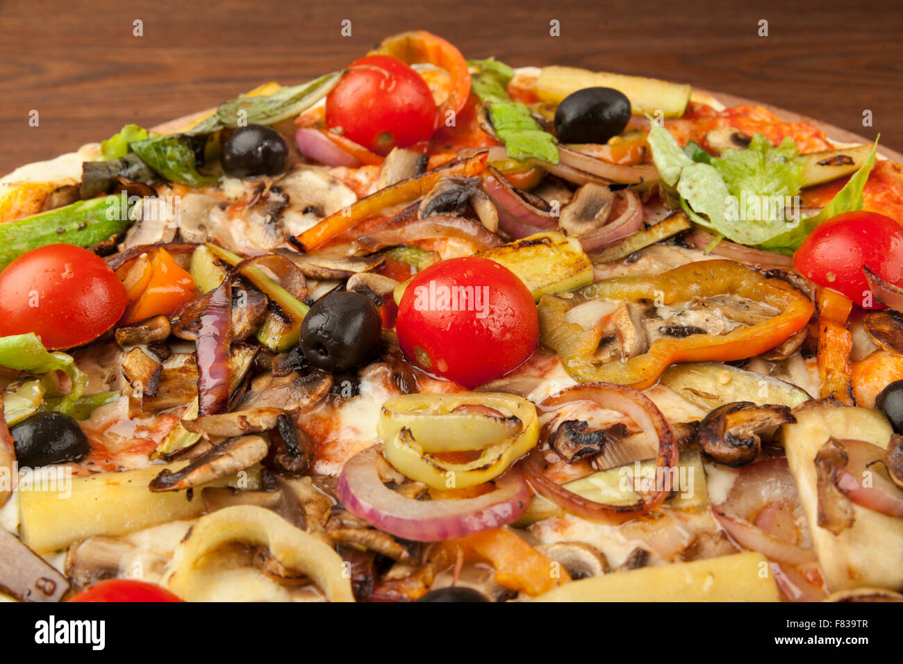 Pizza végétarienne avec des légumes sur plaque de bois Banque D'Images