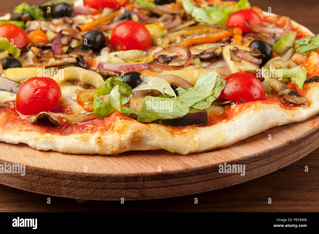 Pizza végétarienne avec des légumes sur plaque de bois Banque D'Images