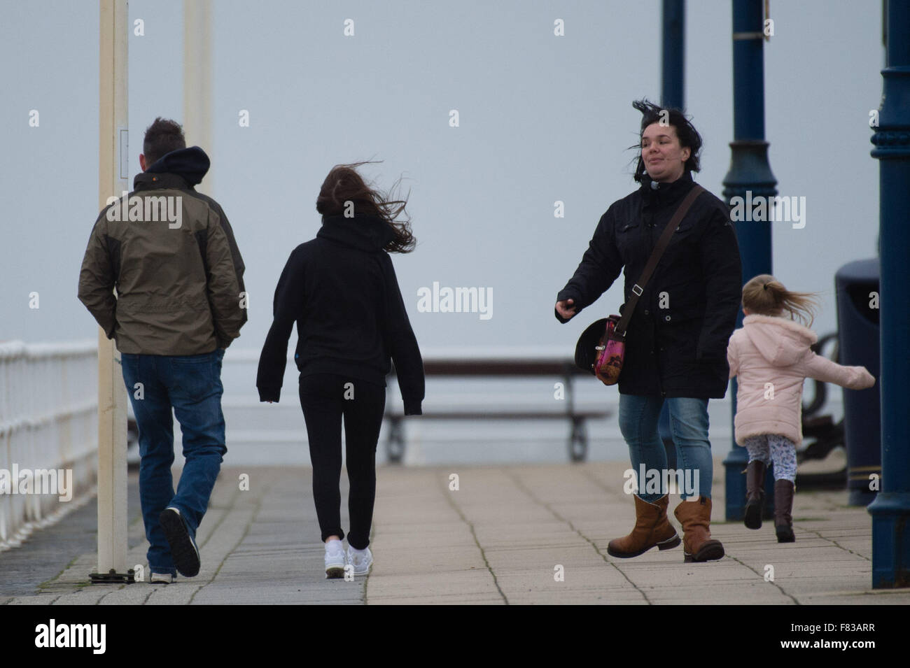 Pays de Galles Aberystwyth UK, Samedi 05 Décembre 2015 Une famille s'envole sur sur la promenade comme le quatrième ouragan de la saison, Storm Desmond, reprend force et commence à batter la côte à l'ouest du pays de Galles, Aberystwyth Photo : © Keith Morris / Alamy Live News Banque D'Images