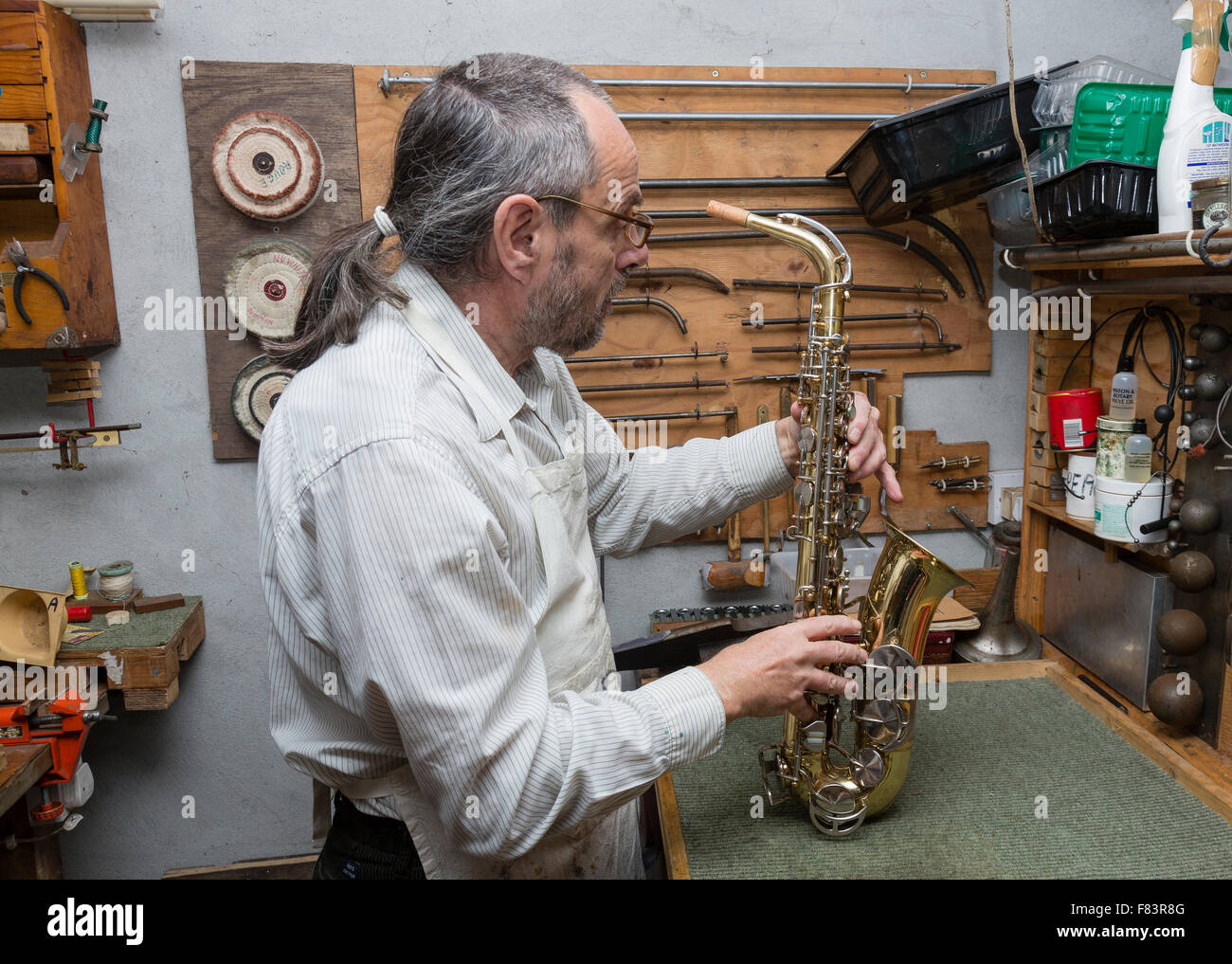 Instrument de musique à vent en laiton et technicien de réparation en atelier, Banque D'Images