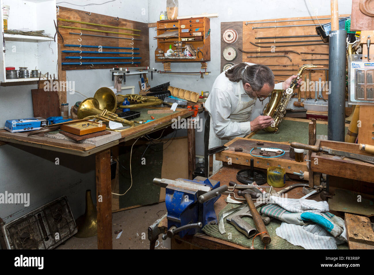 Instrument de musique à vent en laiton et technicien de réparation en atelier, Banque D'Images