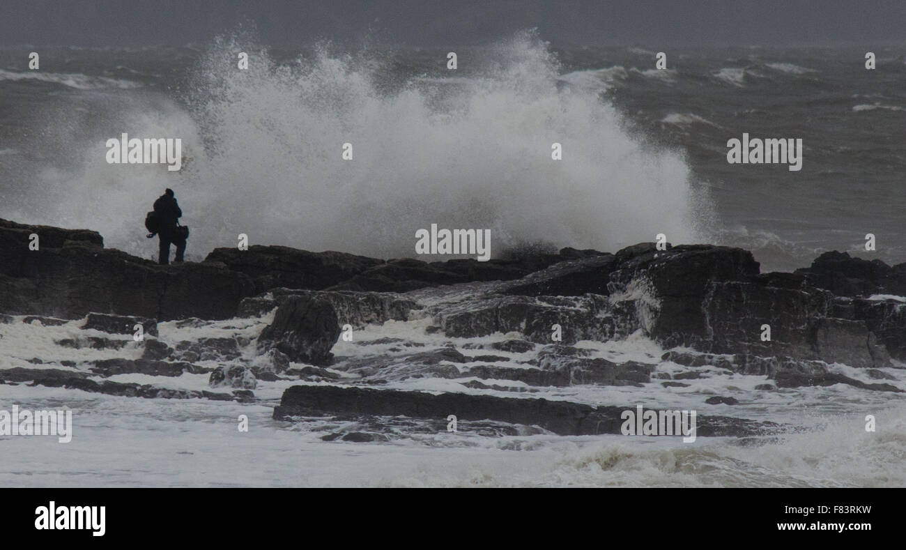 Porthcawl, Pays de Galles, Royaume-Uni, 5 décembre 2015. Un photographe se met en danger pour capturer les énormes vagues battant la côte sud du Pays de Galles. Crédit : Tom Guy/Alamy Live News Banque D'Images