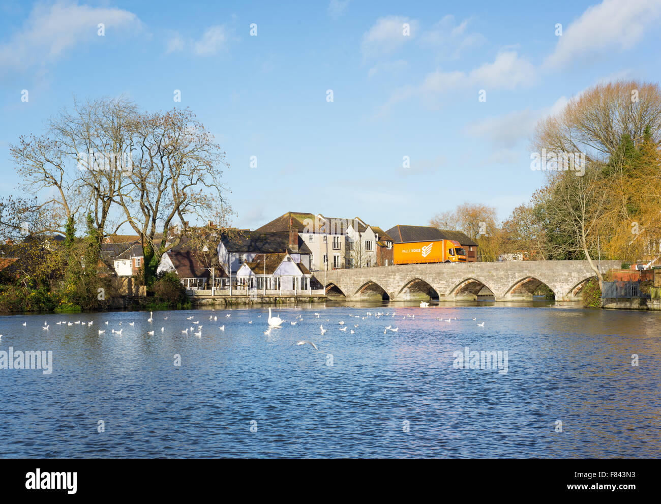 Un camion passant sur le pont en arc de l'autre côté de la rivière Avon à Fordingbridge, Hampshire, Royaume-Uni. Banque D'Images