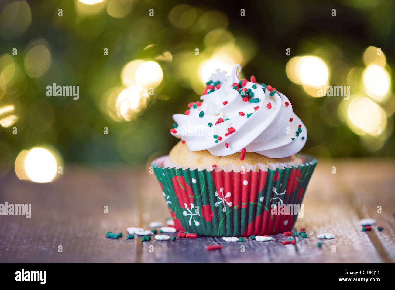 Cupcake de Noël avec des paillettes rouges et verts sur table rustique Banque D'Images