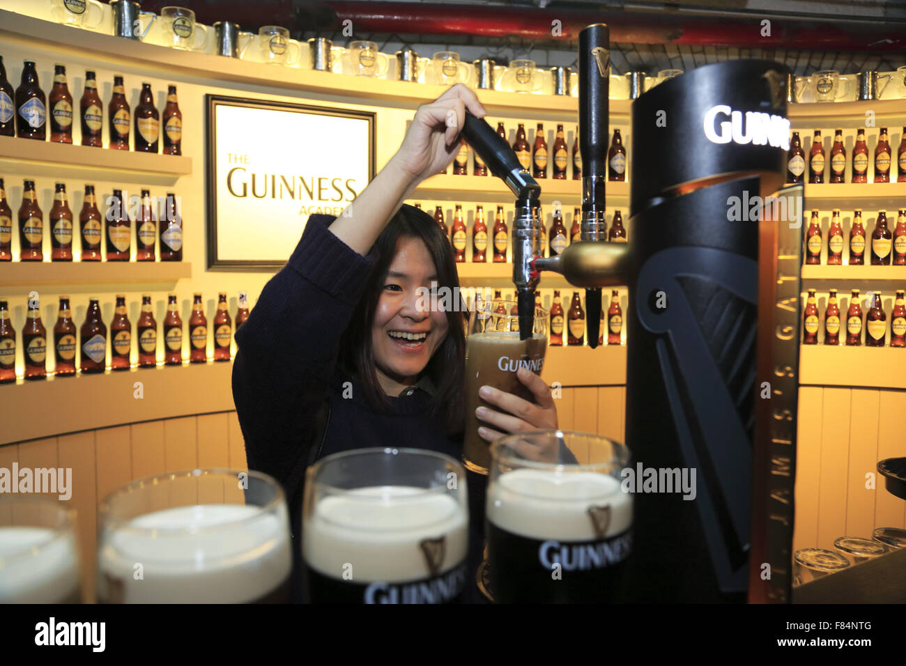 Un touriste chinois apprendre à verser le 'Perfect Pint' dans la barre à Guinness Storehouse, Dublin, Irlande Banque D'Images