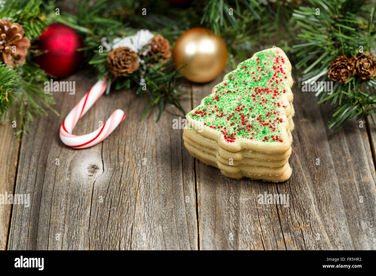 Vue de près avec les cookies en forme d'arbre des branches de conifères, pommes de pin, de neige et ornements sur bois rustique. Selective focus on Banque D'Images
