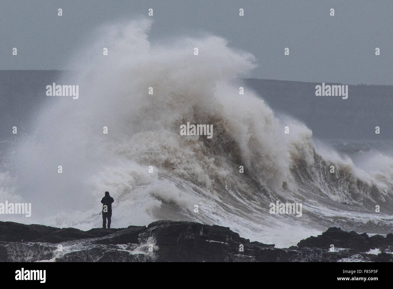 Porthcawl, Pays de Galles, Royaume-Uni. 5 décembre 2015. Un photographe est dangereusement près de la mer à Porthcawl, comme l'impact sur les immenses vagues de tempête phare Desmond. Credit : Polly Thomas/Alamy Live News Banque D'Images