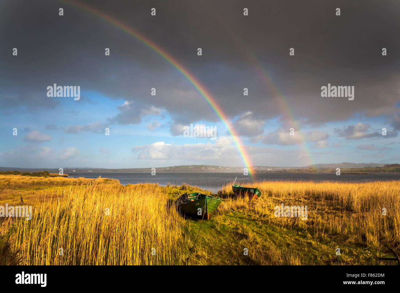 Ardara, comté de Donegal, Irlande la météo. 6e décembre 2015. Après deux jours de pluie incessante pendant une tempête Desmond un arc-en-ciel apparaît au-dessus des lits de roseaux et des bateaux de pêche sur la côte ouest. Crédit : Richard Wayman/Alamy Live News Banque D'Images