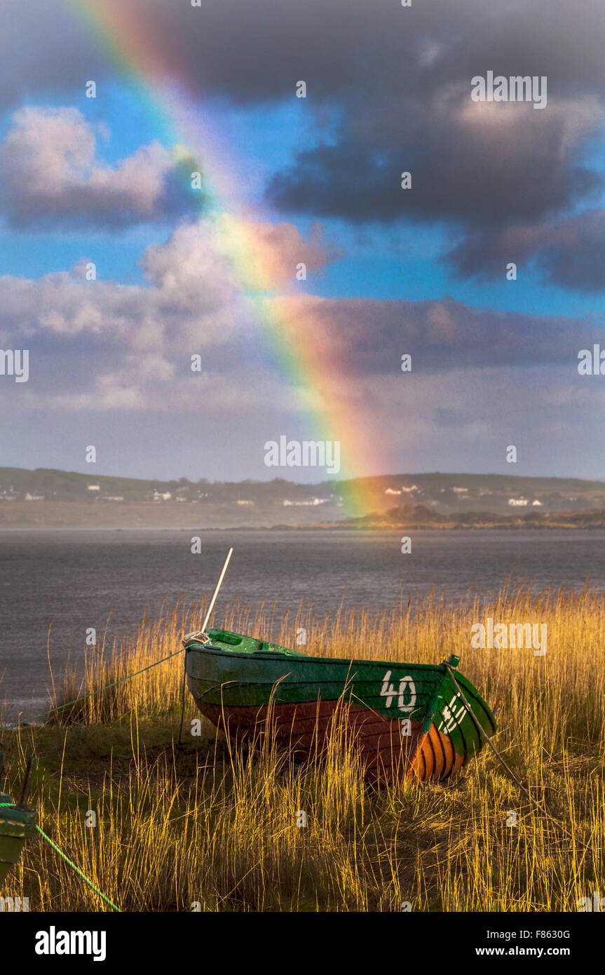 Ardara, comté de Donegal, Irlande la météo. 6e décembre 2015. Après deux jours de pluie incessante pendant une tempête Desmond un arc-en-ciel apparaît au-dessus des lits de roseaux et des bateaux de pêche sur la côte ouest. Crédit : Richard Wayman/Alamy Live News Banque D'Images