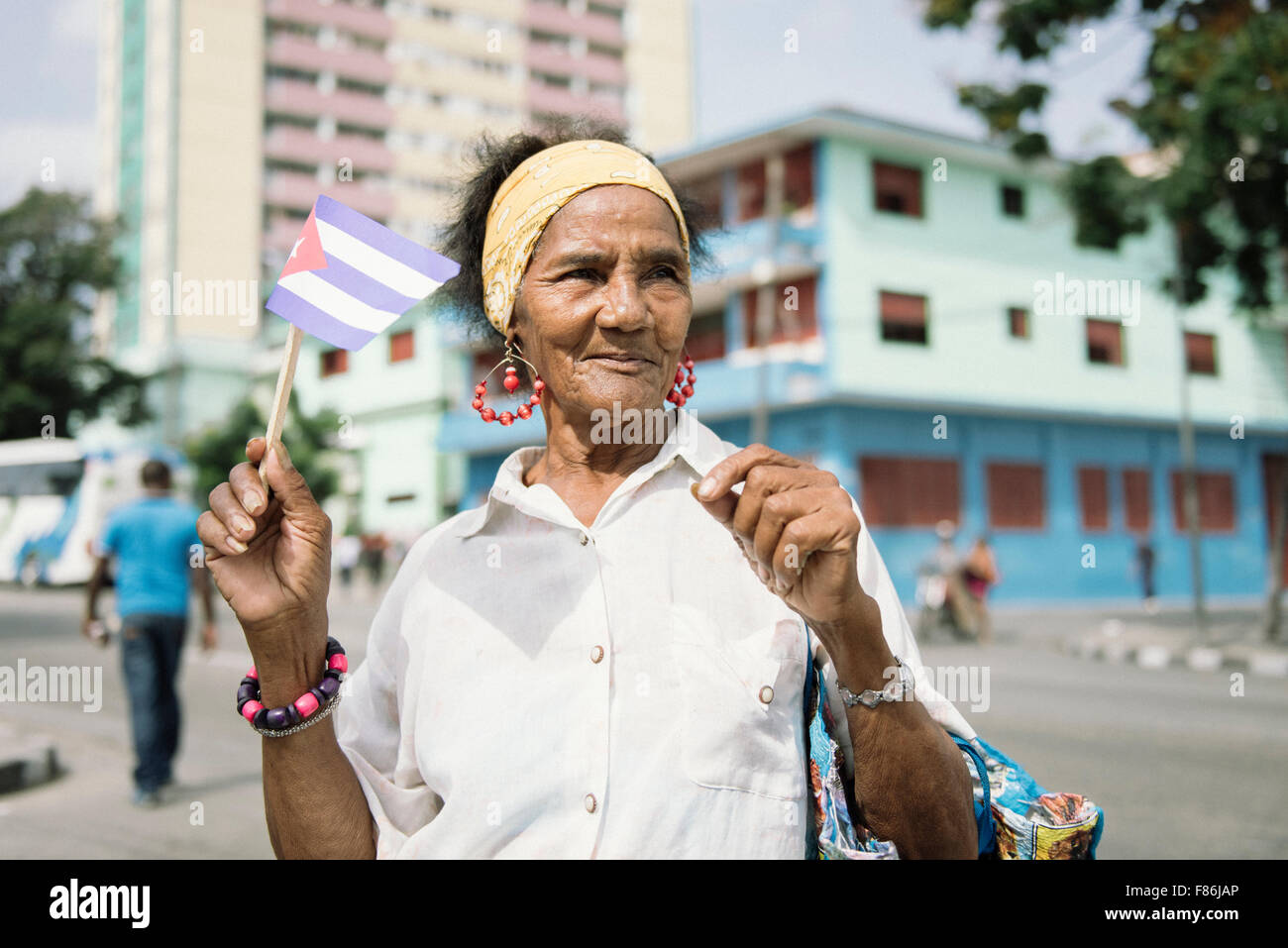 Femme dansant cubain patriotique et la levée du drapeau cubain au cours de la célébration du premier mai à Santiago de Cuba, Cuba. Banque D'Images