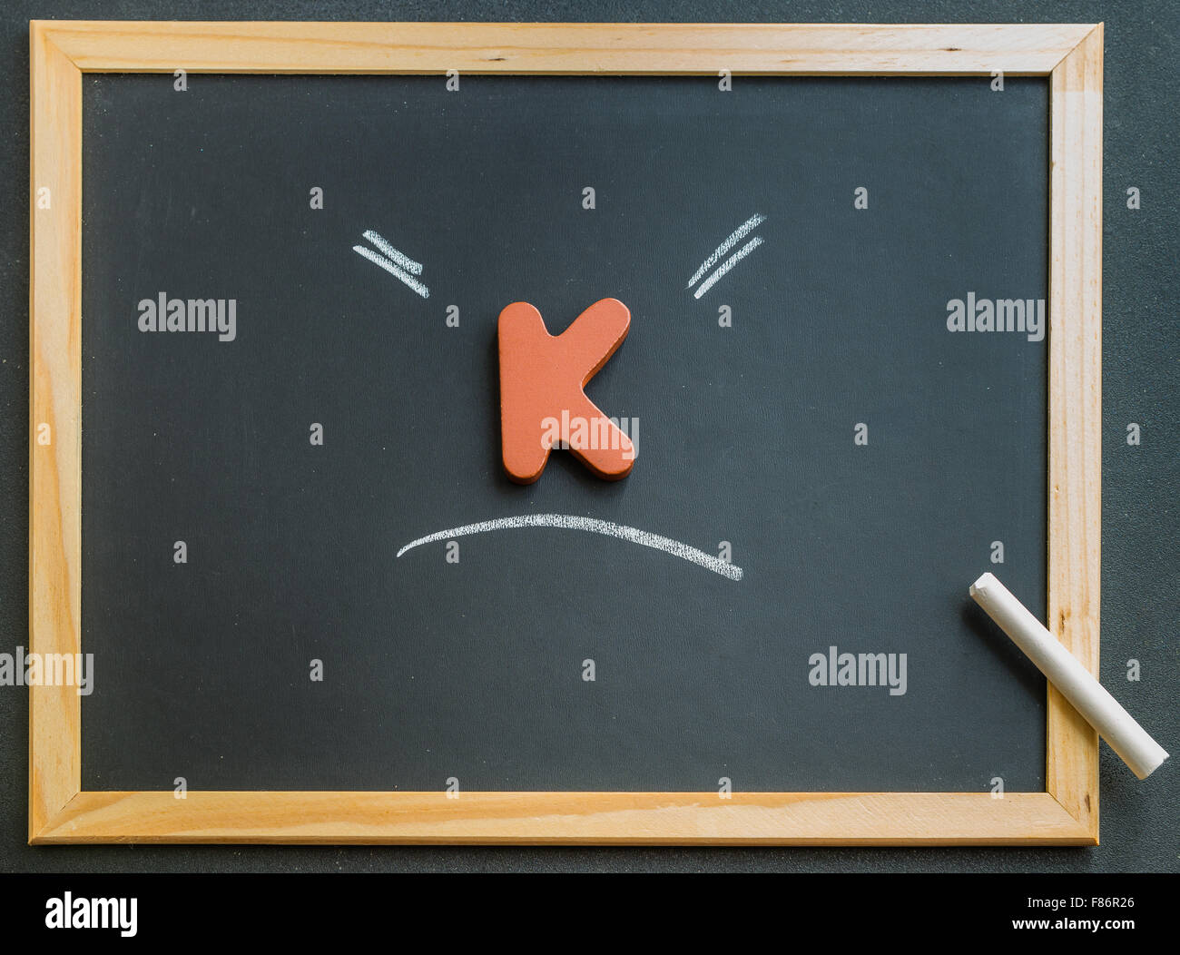 K en bois sur tableau noir charactor Banque D'Images